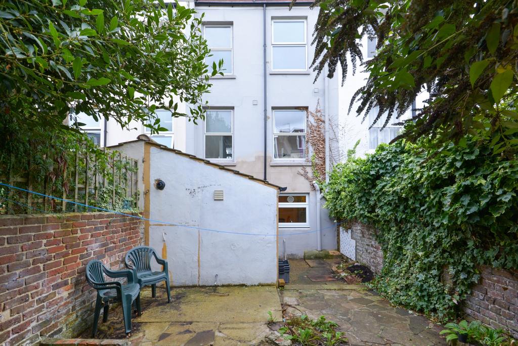 Private paved rear garden with mature greenery,...