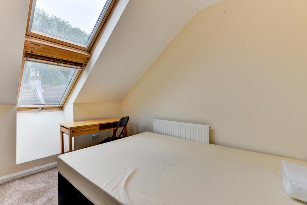 Bright attic single bedroom with a sloped ceili...