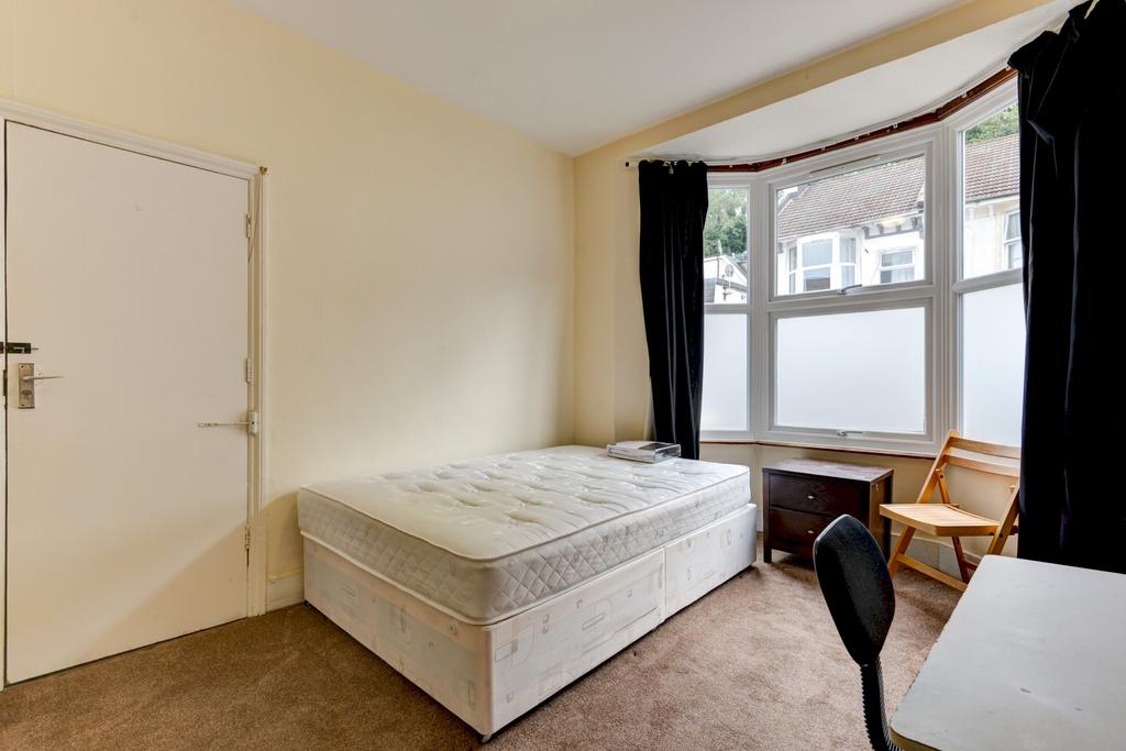 Bright, simply furnished bedroom with a comfort...