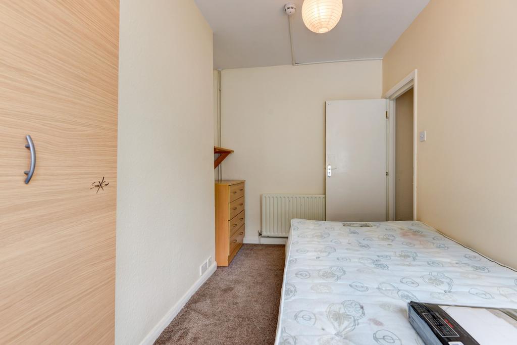 A simply furnished bedroom with a double bed an...