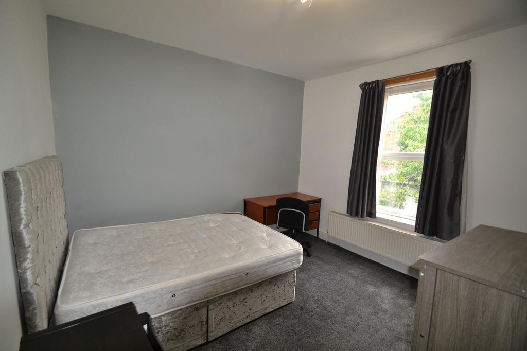 A cozy bedroom featuring a single bed with a pa...