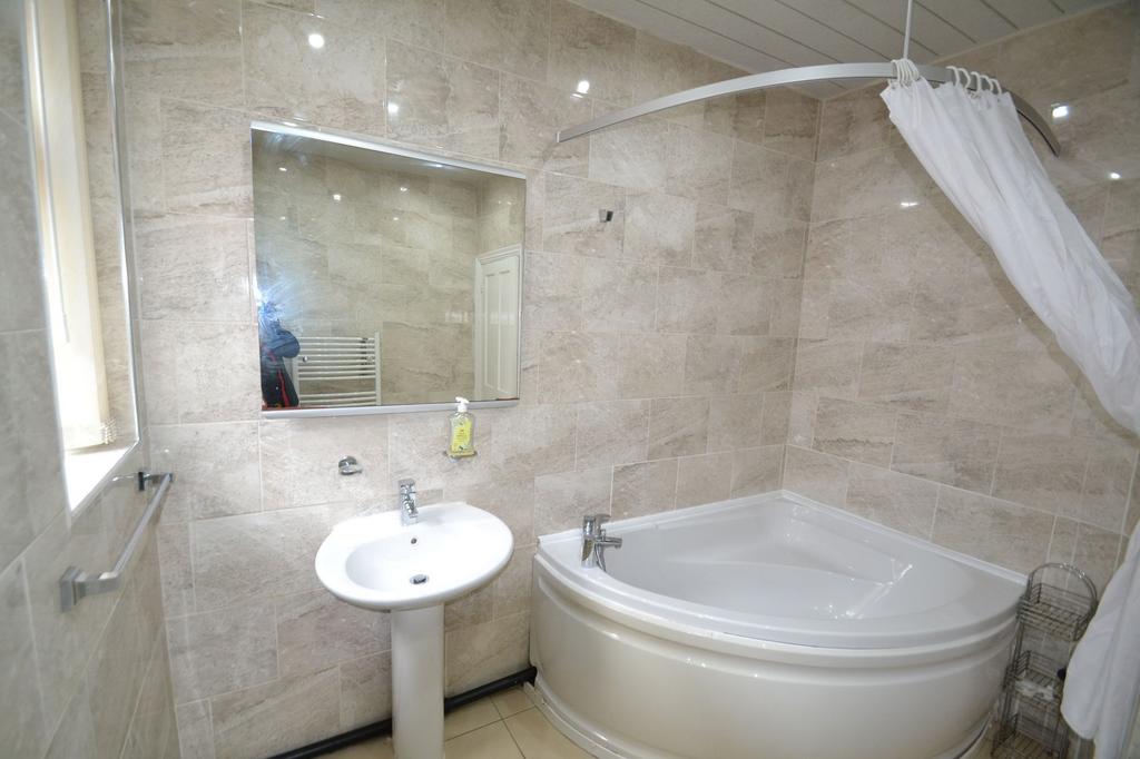Bright and clean bathroom featuring a corner ba...