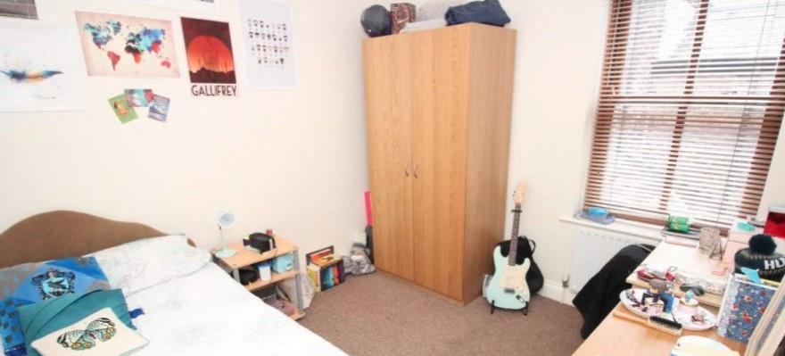Bright, neatly kept bedroom with natural light ...