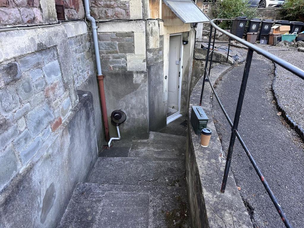 Exterior stone entrance with steps leading down...