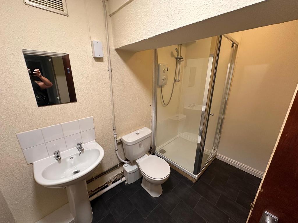 Clean ensuite bathroom with a corner shower cub...