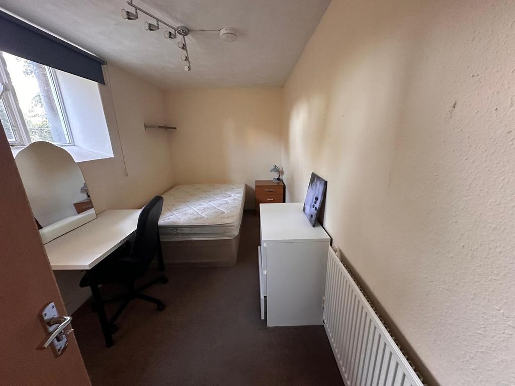 Neat single bedroom with a large window providi...