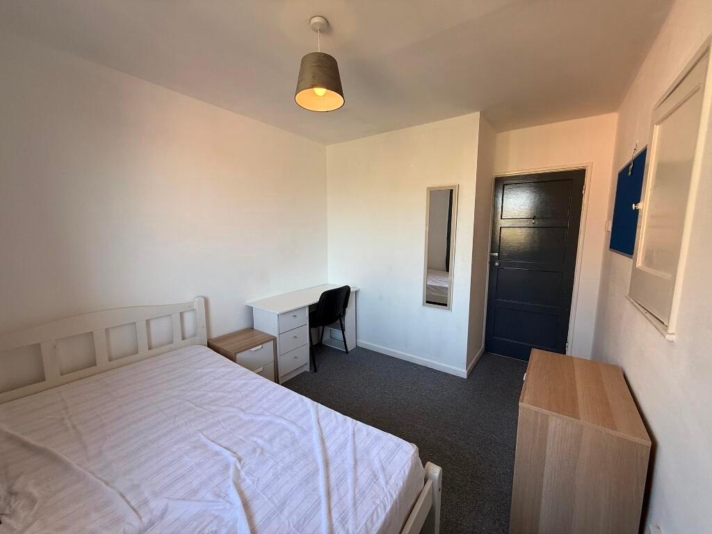 Bright, simply furnished bedroom with a double ...
