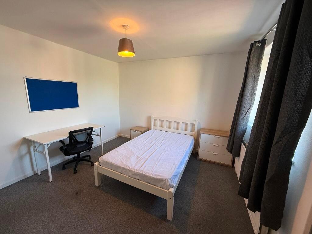 Bright, simply furnished double bedroom with a ...