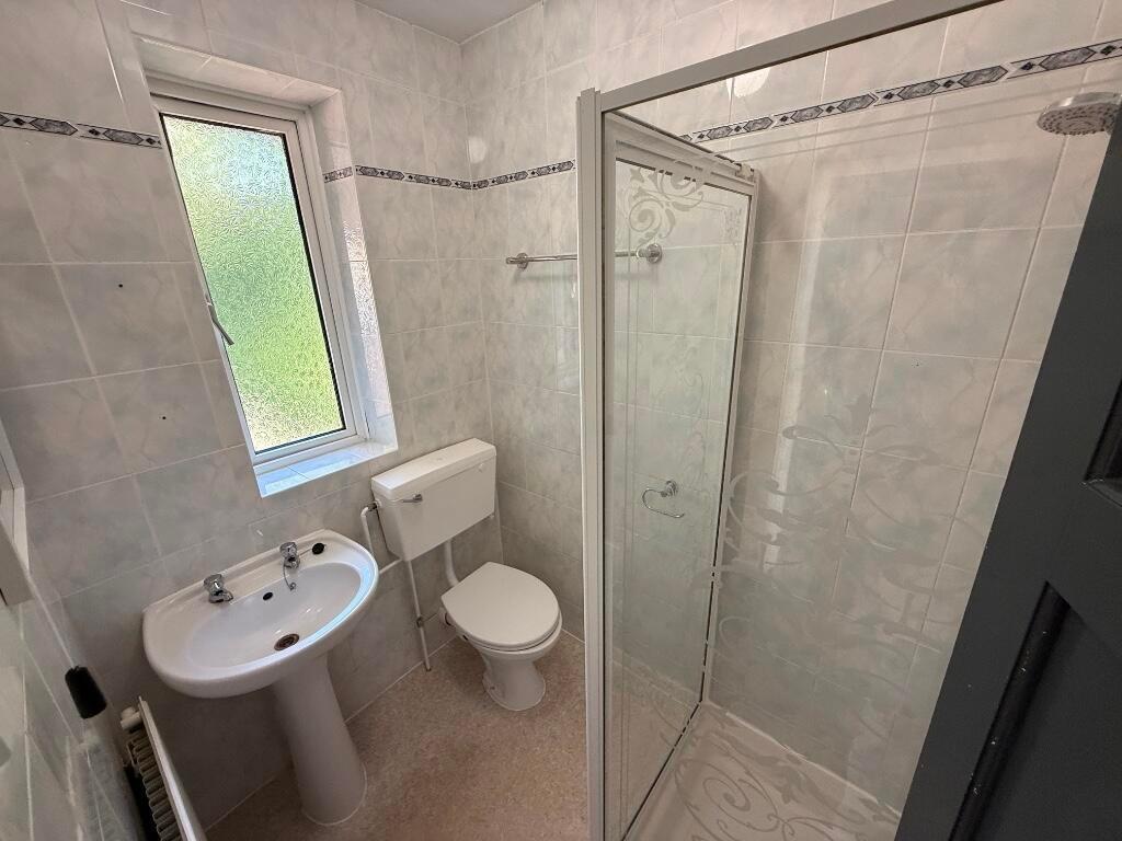 Bright, tiled bathroom with a walk-in shower, p...