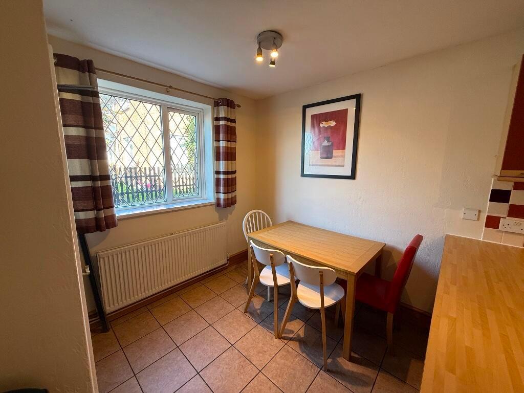 Bright eat-in kitchen with a large window, tile...