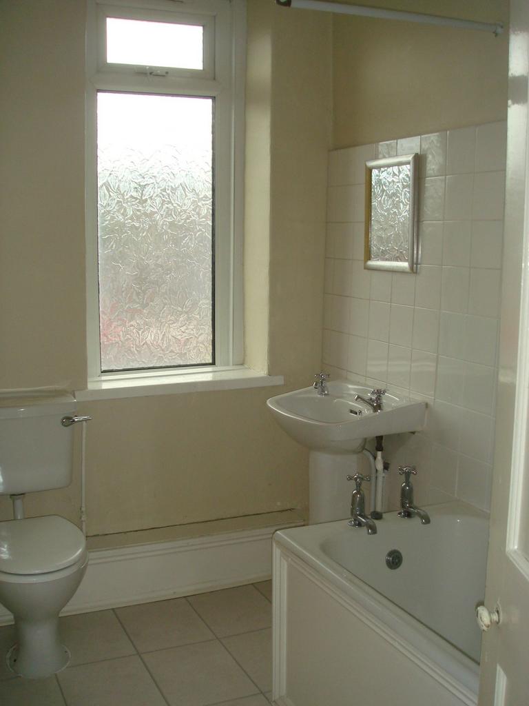 A functional bathroom with a small bathtub, a s...