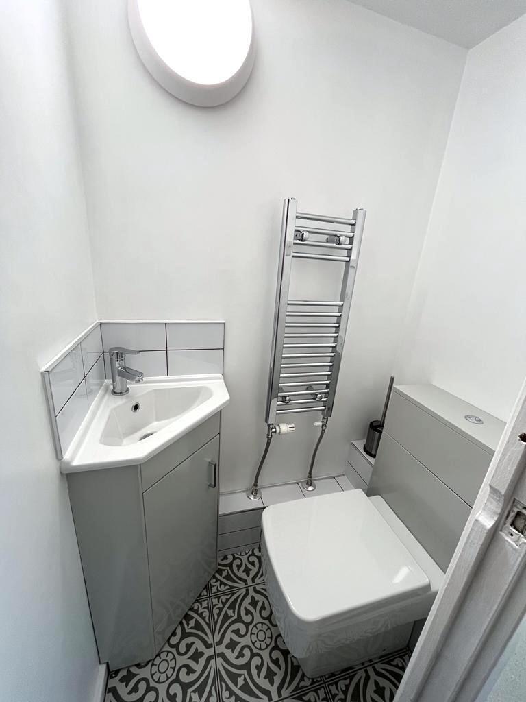 Bright, modern bathroom with a compact corner b...