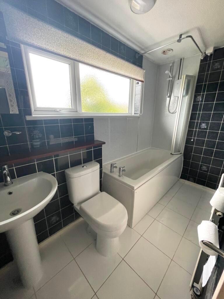 Bright, well-maintained bathroom with a tiled f...