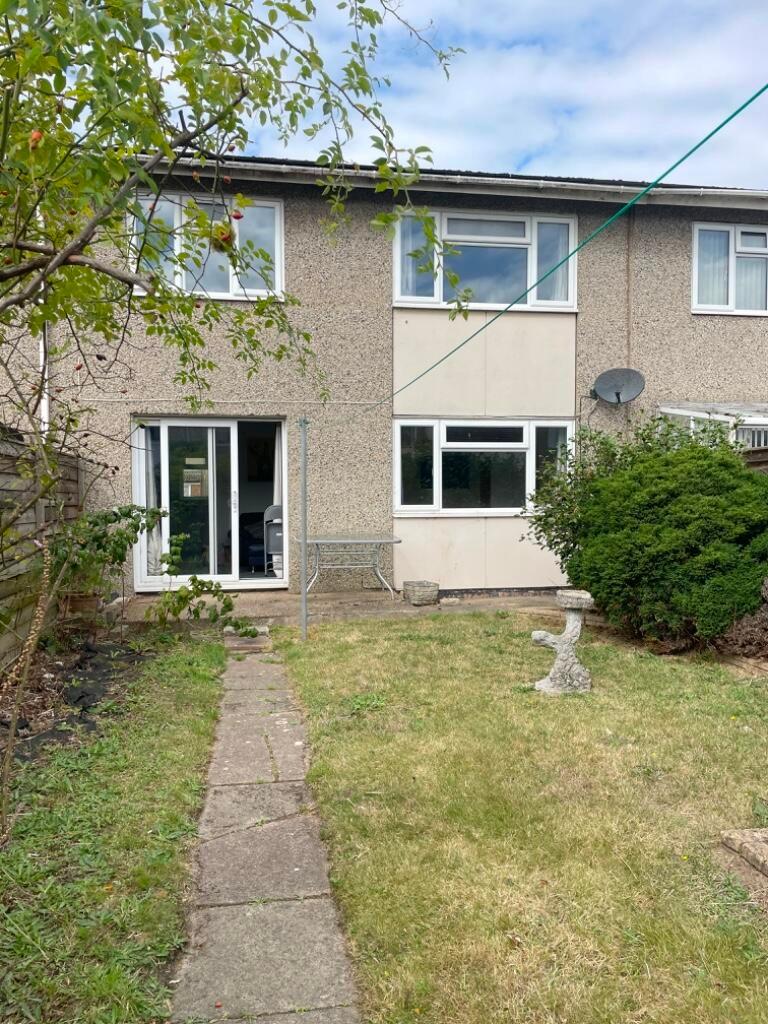 Rear garden with paved path leading to patio do...