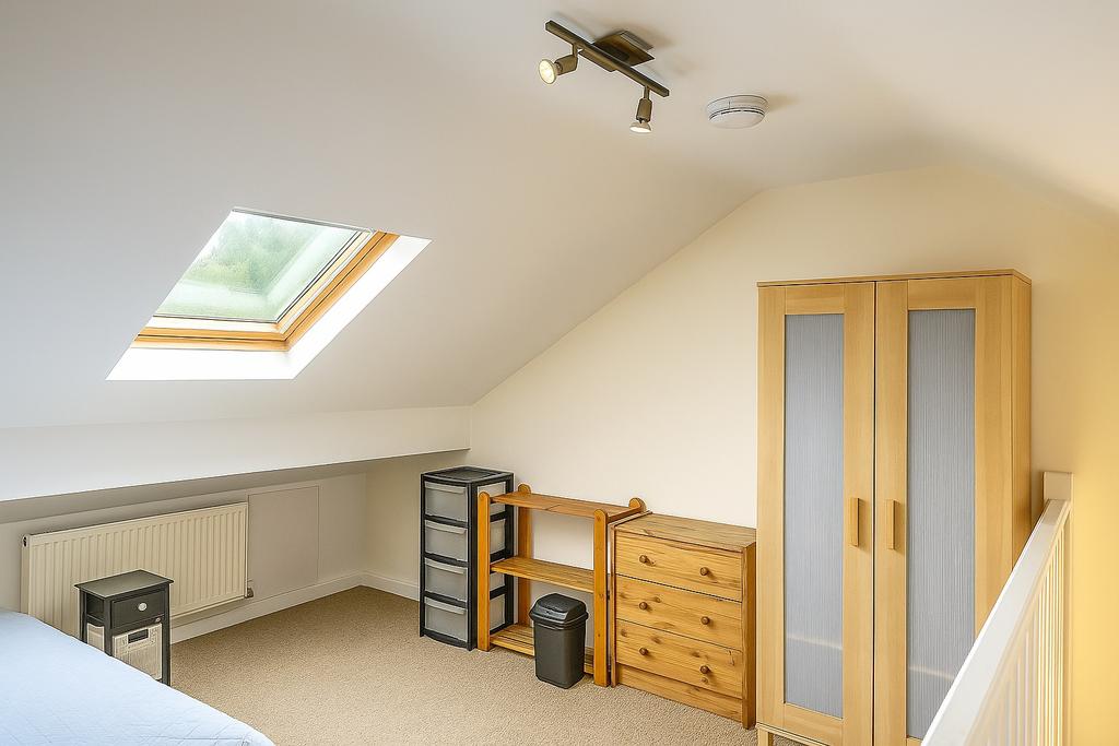 Bright attic bedroom with a large skylight, lig...