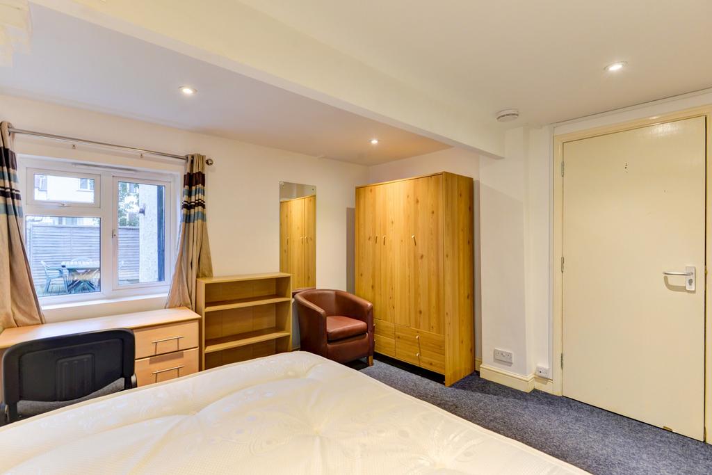 Bright double bedroom with a large window, fitt...