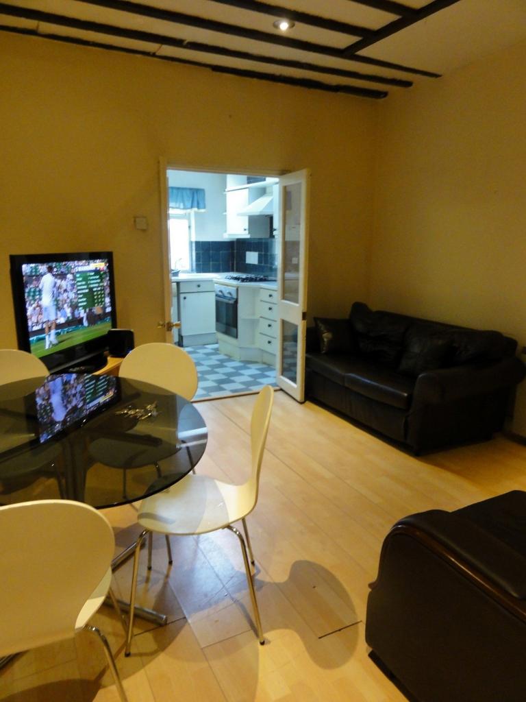 A cozy living room featuring a television, a ro...
