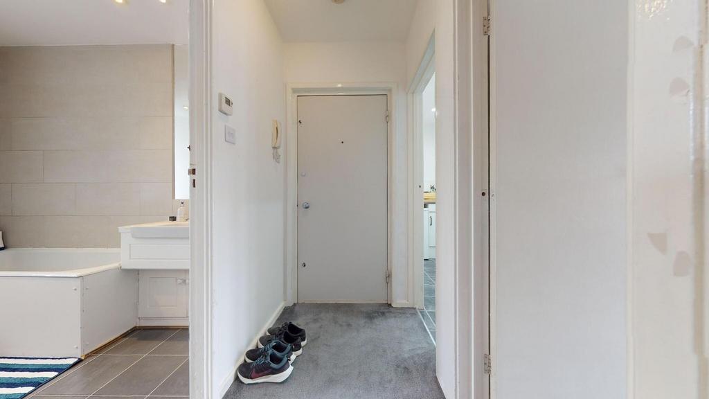 Bright, neutral hallway with soft carpeting, a ...