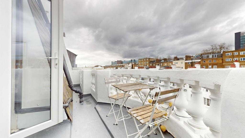 Sunny rooftop balcony with a small bistro table...