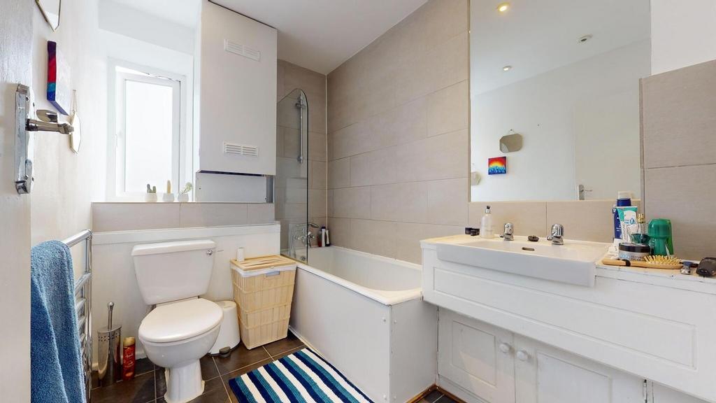 Bright, well-maintained bathroom with a bathtub...