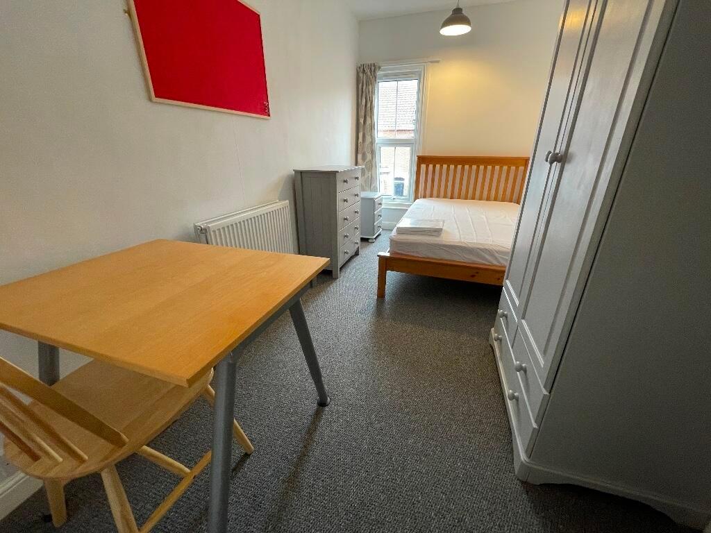 Bright, simply furnished bedroom with a wooden ...