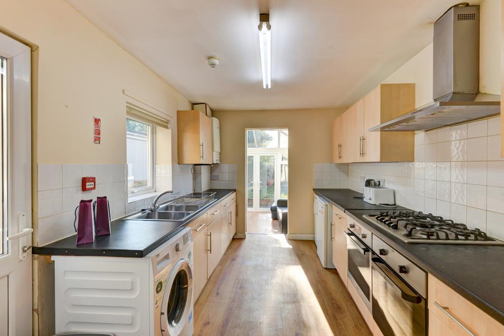 Bright galley kitchen with modern appliances, g...