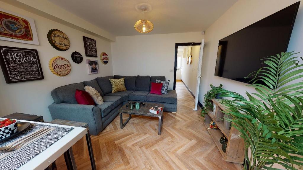 A spacious, well-lit living room featuring a la...