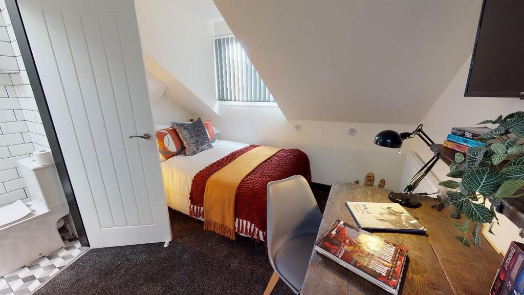 A cozy and well-lit bedroom with a comfortable ...