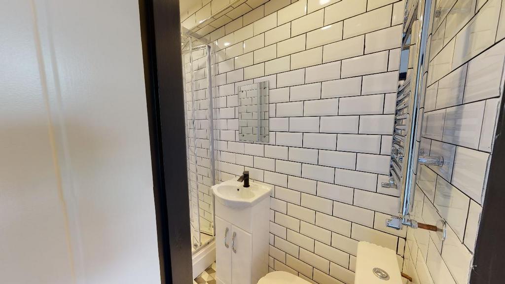 A modern, clean bathroom with white subway tile...
