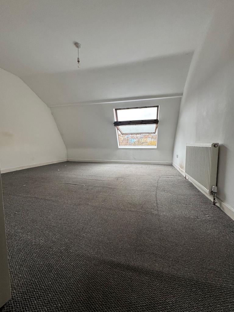 Bright attic bedroom with a large skylight, neu...