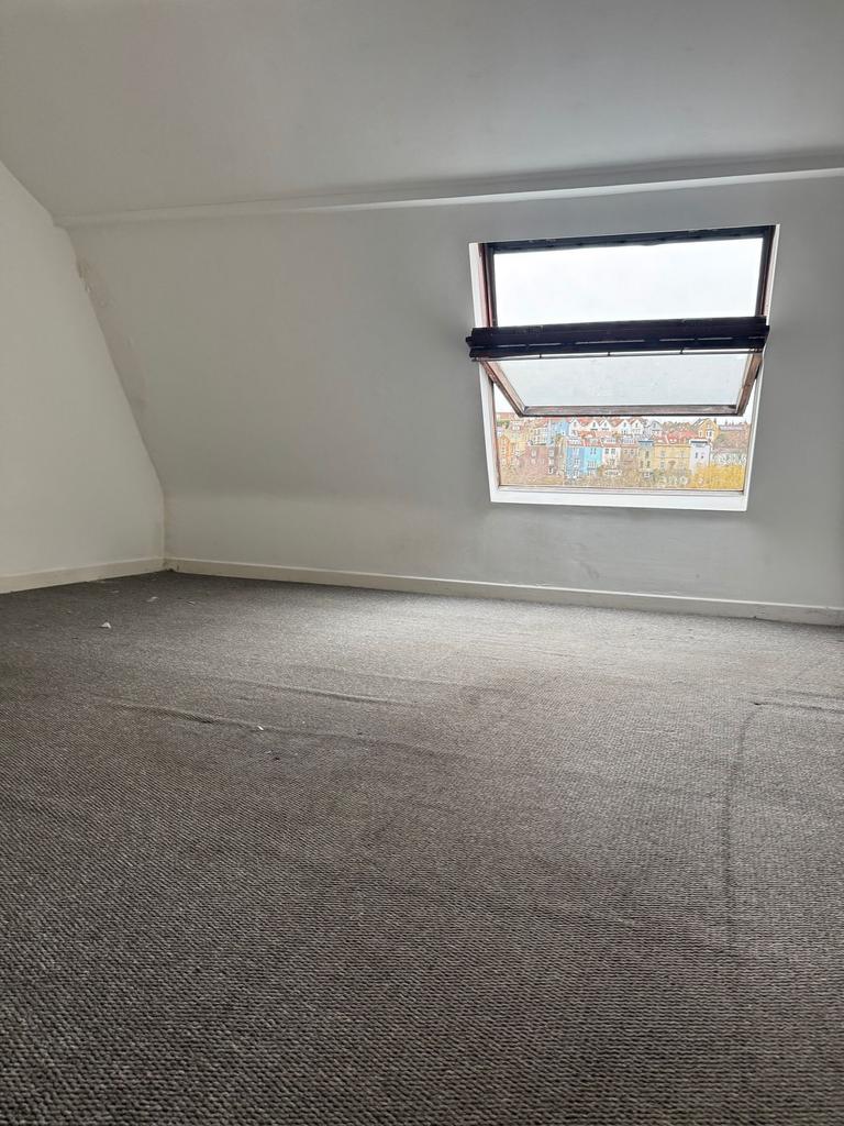 Bright attic bedroom with a large skylight offe...