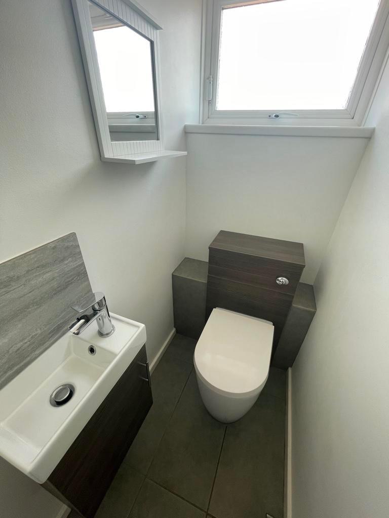 Bright, modern cloakroom with contemporary WC a...