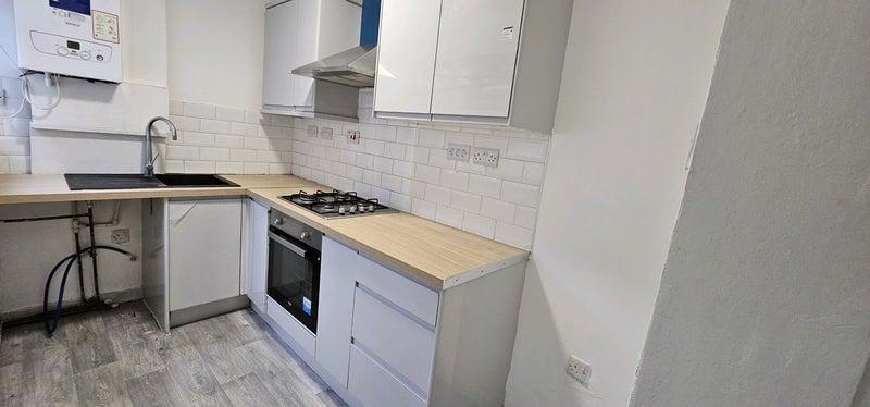 Modern galley kitchen with wood countertops...