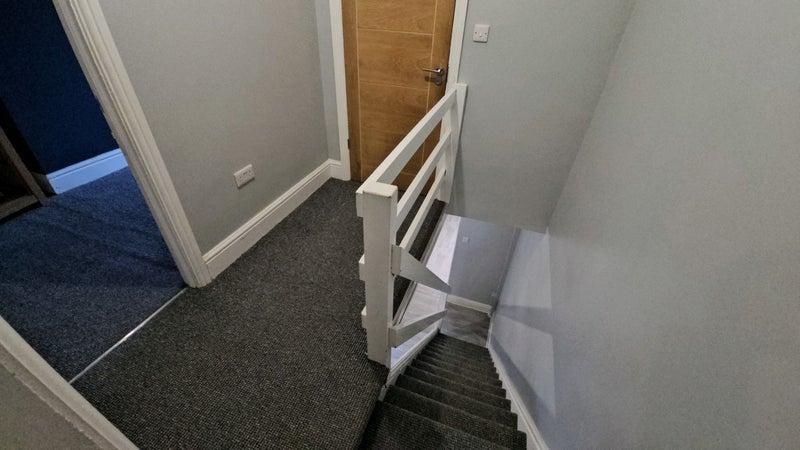 Bright painted landing with carpeted stairs...