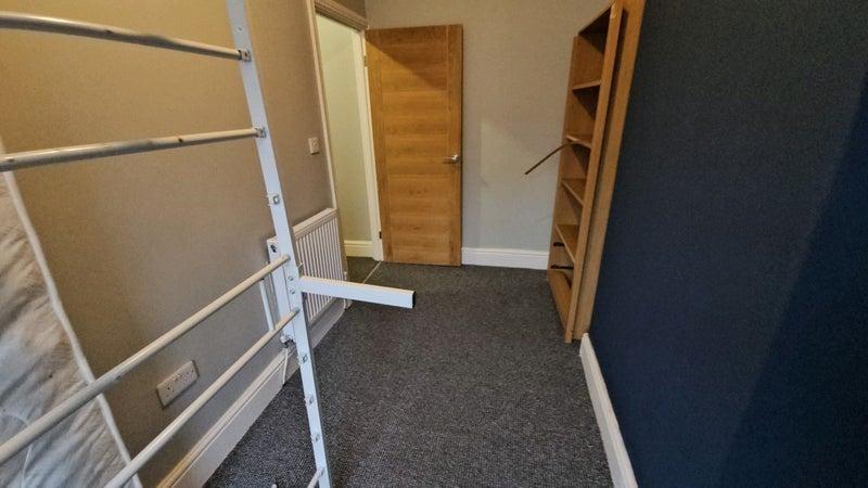 Compact bedroom with shelving and neutral décor...