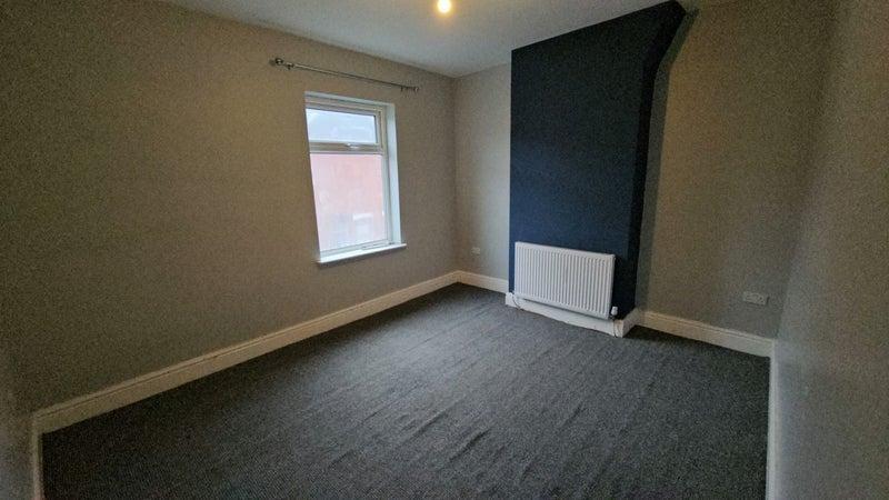 Neutral double bedroom with feature wall and ne...
