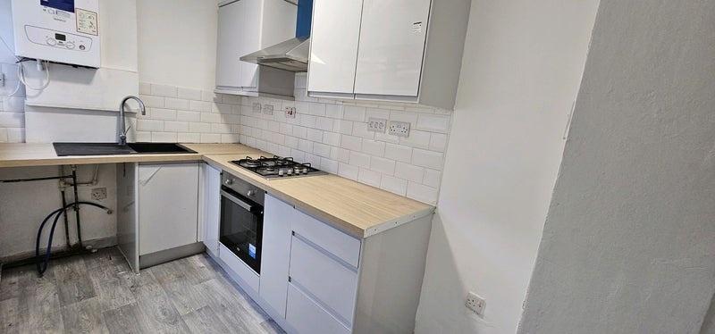 Modern fitted kitchen with gas hob and sink...