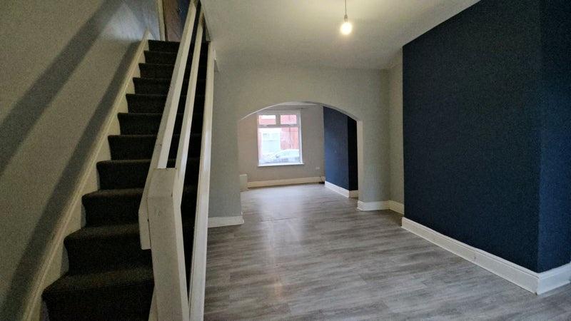 Open-plan living area with archway and staircas...