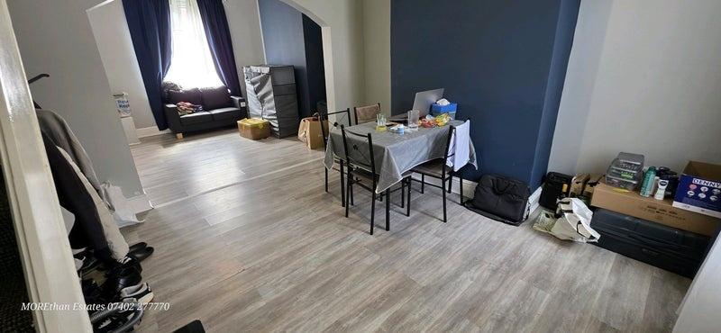 Spacious lounge with large window and dining ar...
