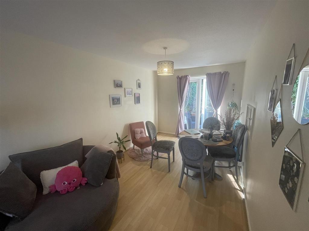 Bright furnished living/dining area with seatin...