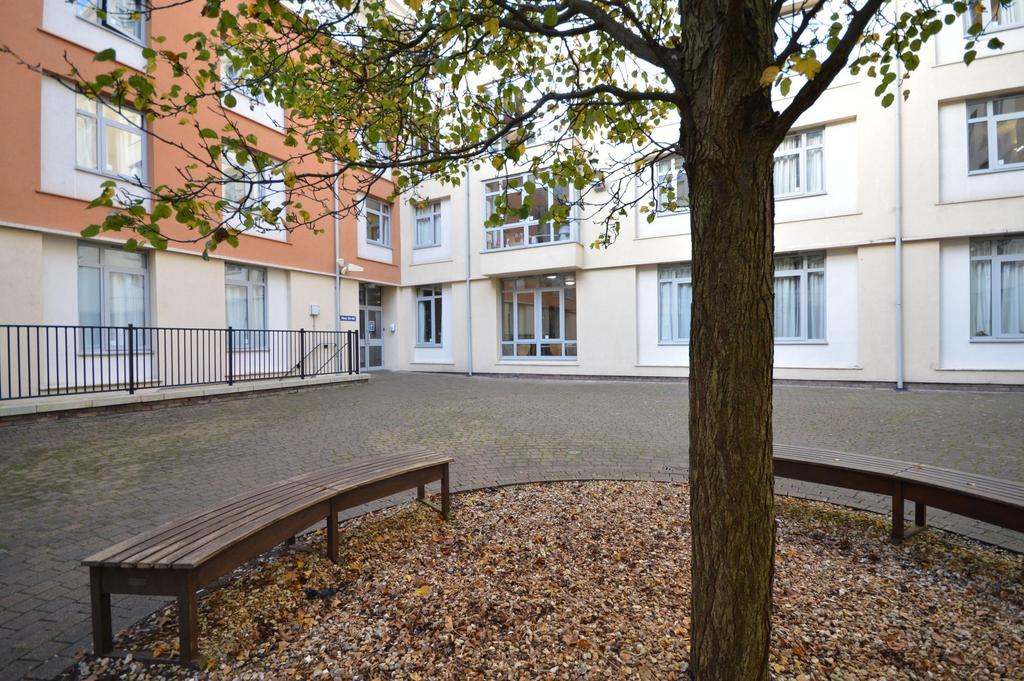 Quiet paved courtyard with curved benches...