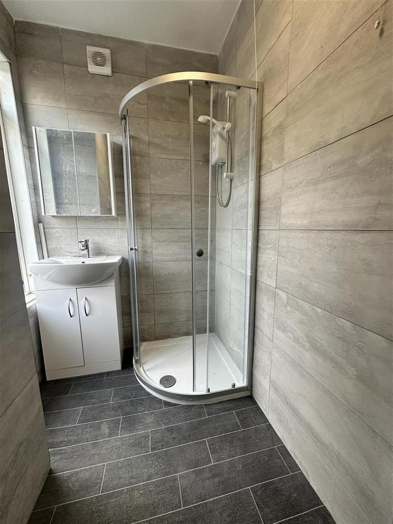 Modern tiled bathroom with corner shower...