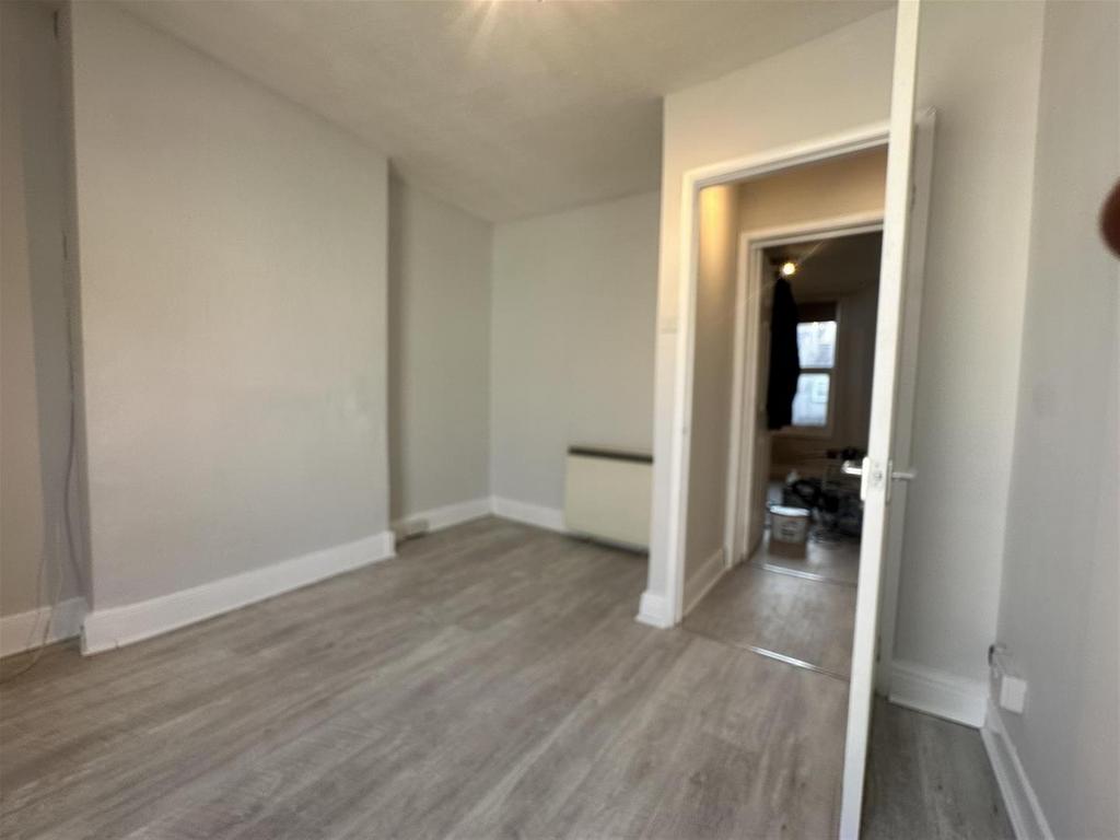 Bright, neutral single bedroom with wood floori...