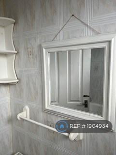 Fully Tiled Bathroom With Mirror And Shelf