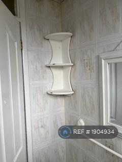 Fully Tiled Bathroom With Mirror And Shelf