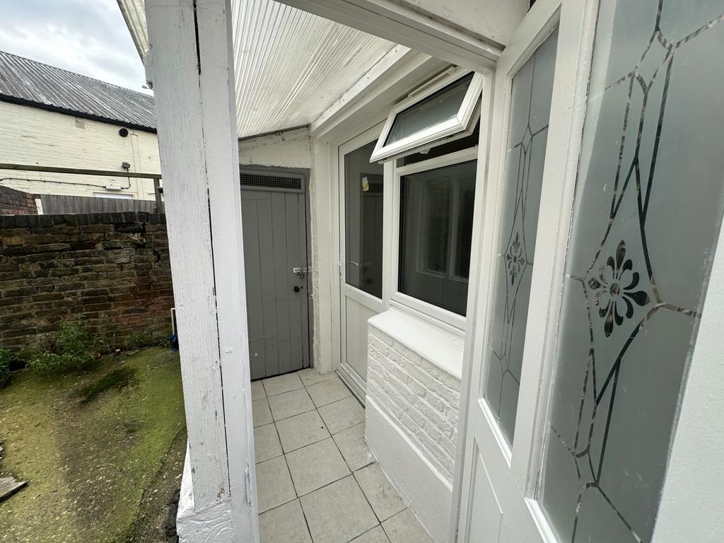 Covered porch/entrance with tiled step and side...