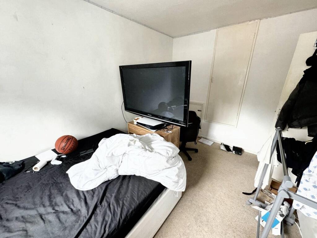 Compact bedroom with TV and bed...