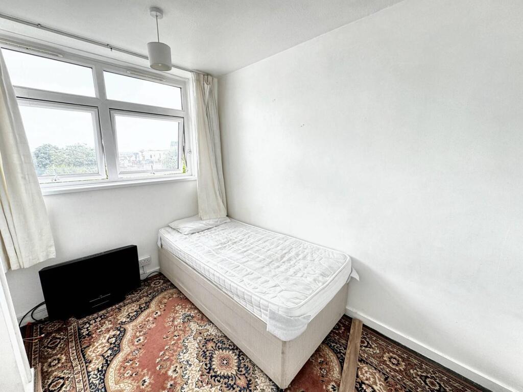 Bright bedroom with large window and neutral de...