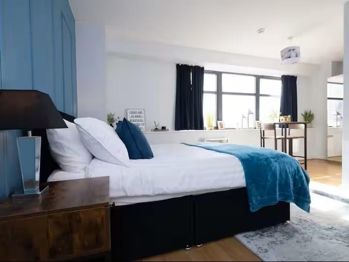 Bright, modern master bedroom with a neatly mad...