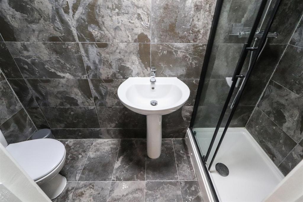 Modern tiled bathroom with a corner shower encl...